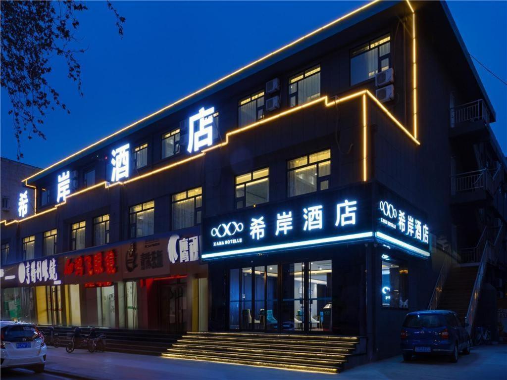 a building with neon signs on the side of it at Xana Hotelle·Zibo Shandong University of Technology East Campus in Zibo