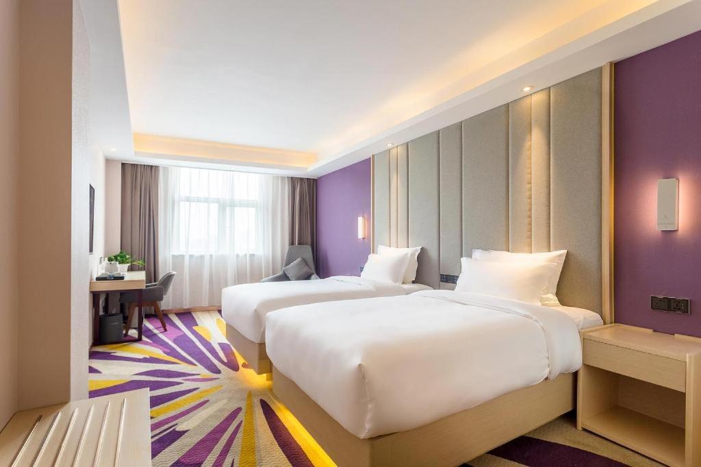北京市にあるLavande Hotel·Beijing Capital Airport Xiedaoの紫の壁のホテルルーム内のベッド2台