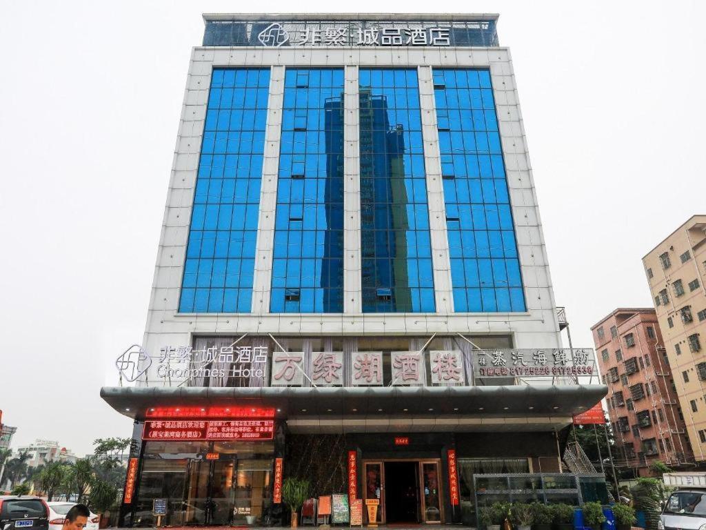 a tall building with blue windows in a city at Chonpines Hotel Shenzhen Gongming Honghuashan Metro Station in Shenzhen