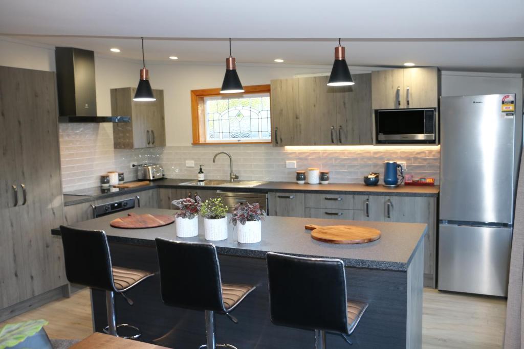 a kitchen with a table with chairs and a refrigerator at Alpine Views Burkes Pass in Burkes Pass