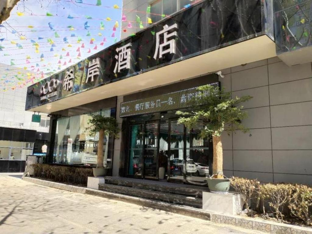 un bâtiment avec un panneau à l'avant dans l'établissement Xana Hotelle·Lianyungang Donghai, à Donghai