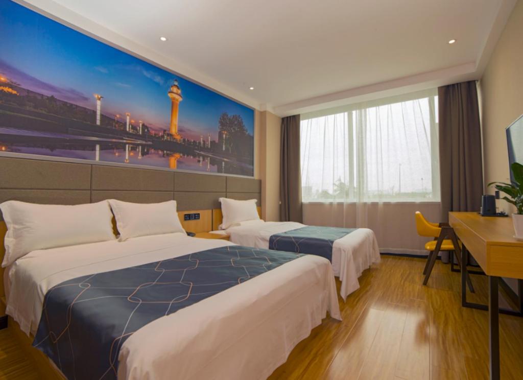 a hotel room with two beds and a desk at Chonpines Hotel·Rizhao Yingbing Road RT-Mart in Rizhao