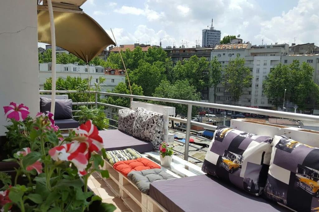 uma varanda com sofás e plantas num edifício em 200 m2 Centre Penthouse Amazing Balcony em Belgrado