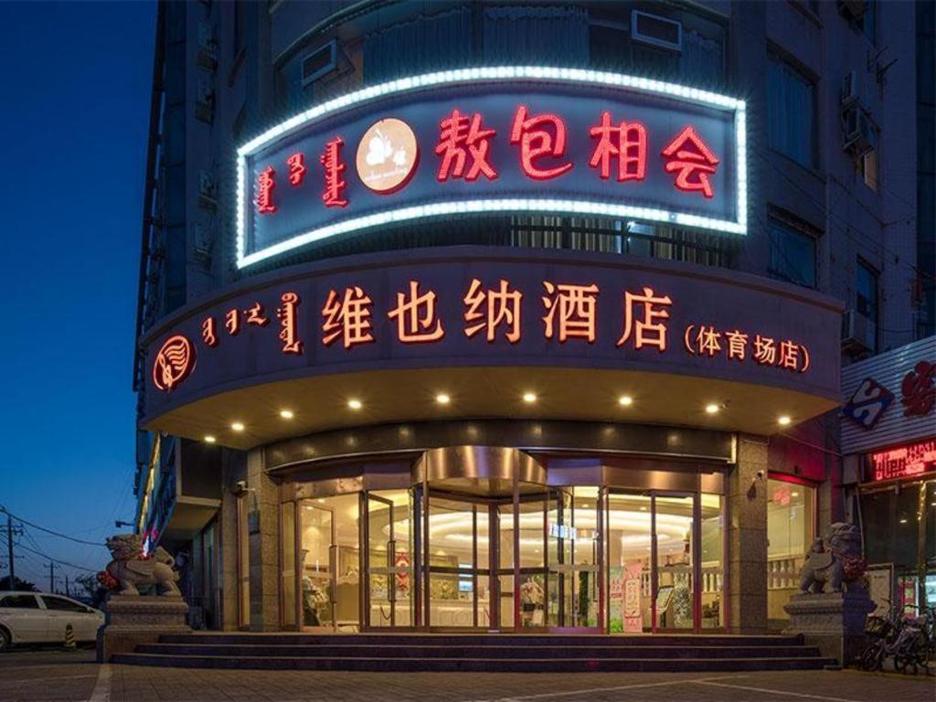 un edificio con letreros de neón en la parte delantera en Vienna Hotel Inner Mongolia Hohhot Railway Station Gongzhufu Metro Station, en Hohhot
