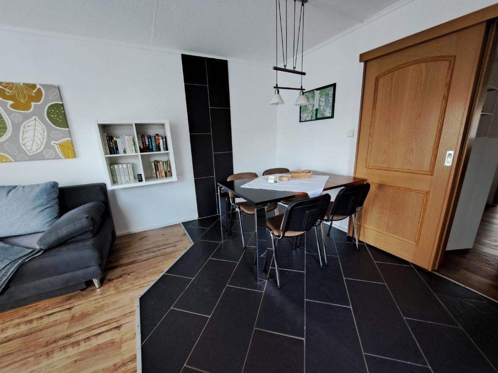 ein Wohnzimmer mit einem Tisch, Stühlen und einem Sofa in der Unterkunft 3 Sterne FH Fürstenwalde in Fürstenwalde