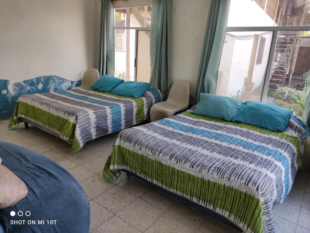 2 Betten in einem Zimmer mit Fenster in der Unterkunft Luz del Mar Paredón in El Paredón Buena Vista