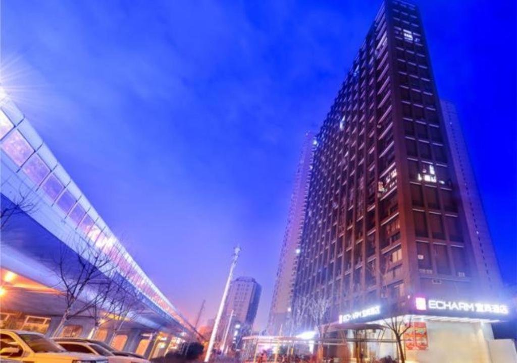 a tall building in a city at night at Echarm Hotel Wuhan Huangpu Erqi Xiaolu Metro Station in Jiang'an