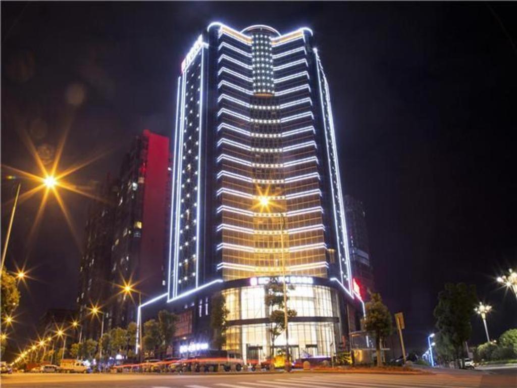 a tall building with lights on it at night at Echarm Hotel Huaihua Vocational College in Huaihua