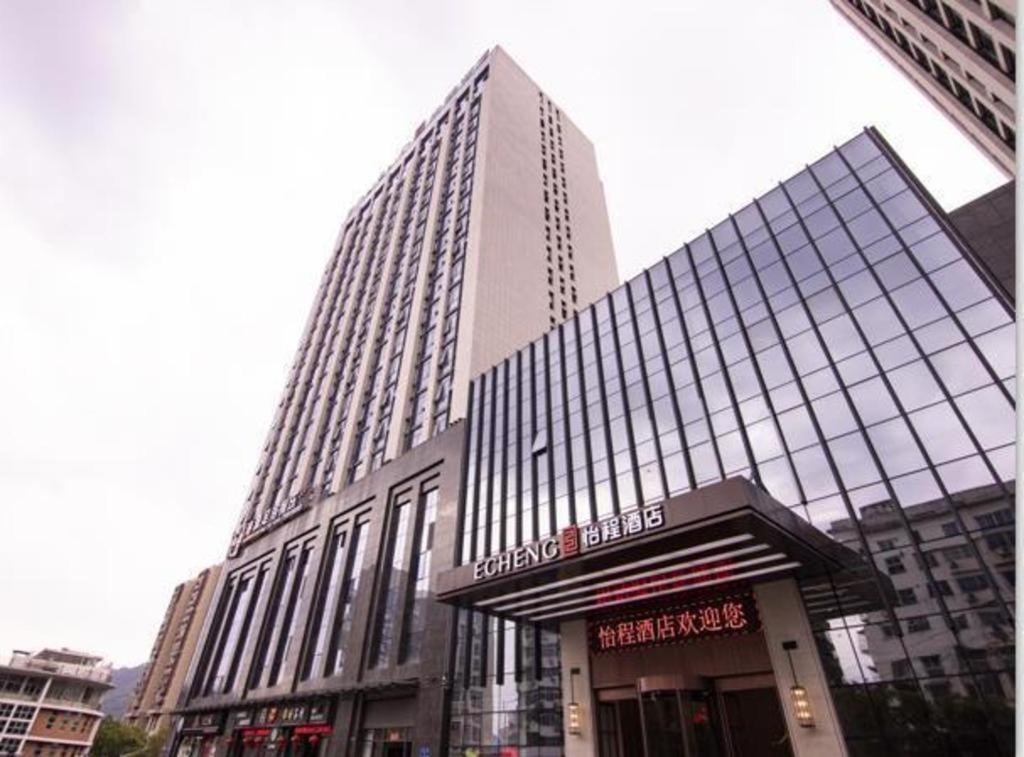 een hoog gebouw met een winkel ervoor bij Echeng Hotel Sanming City Government RT-Mart in Sanming