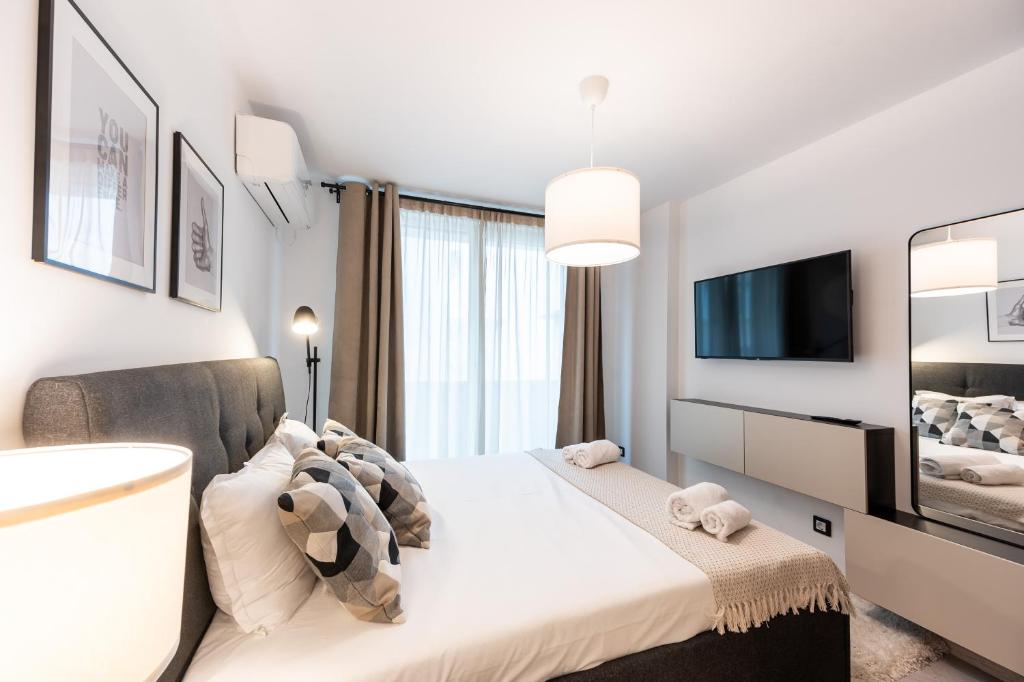 1 dormitorio con 1 cama grande y TV en Central View Apartment 1, en Blagoevgrad