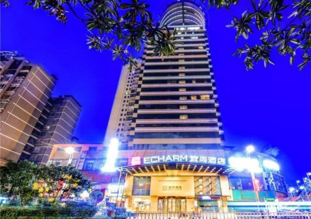 a tall building with a sign on it at night at Echarm Hotel Zunyi Conference Site Gang'ao Branch in Zunyi