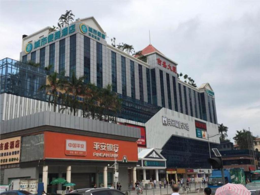 ein großes Gebäude an einer belebten Stadtstraße mit Autos in der Unterkunft City Comfort Inn Shenzhen Longhua Guanlan Metro Station in Tiantangwei