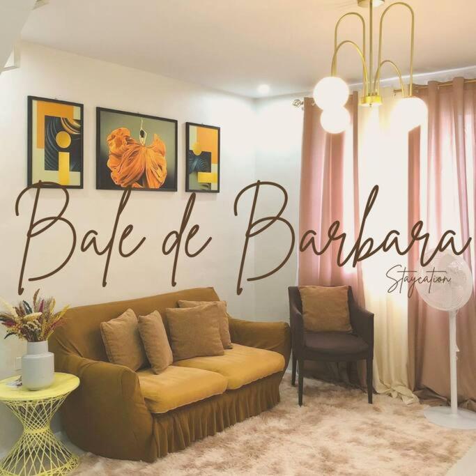 a living room with a couch and a large sign at Bale de Barbara in Pampang