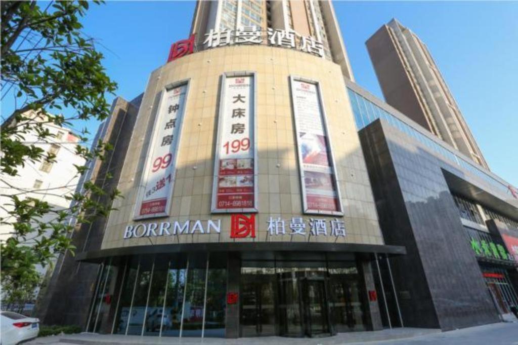 Borrman Hotel Huangshi Daye High-speed Railway North Station Qihao Garden في Daye: مبنى عليه لافتات