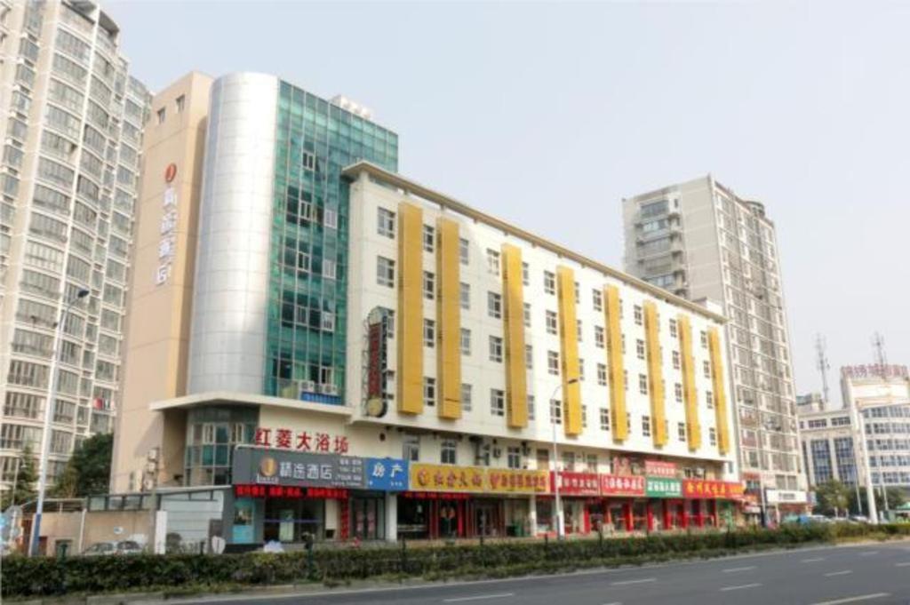 常州的住宿－JTOUR Inn Changzhou Wanda Plaza Railway Station，一座大建筑,上面有黄色和红色的标志