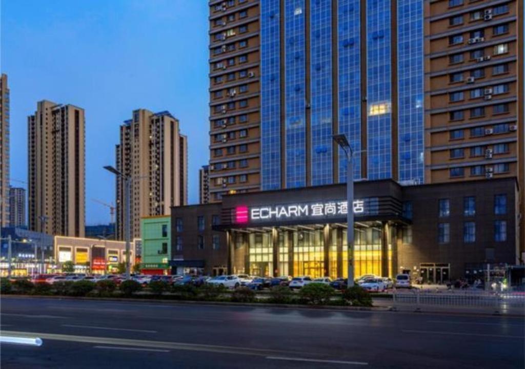 a building in a city with tall buildings at Echarm Hotel Heze Renmin Road Peony Garden Railway Station in Heze