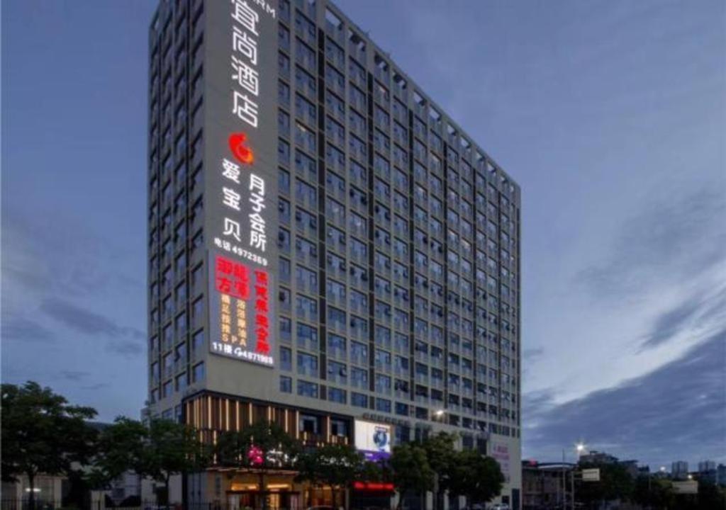 a tall building with a sign on the side of it at Echarm Hotel Nanning Chaoyang Square River View in Nanning