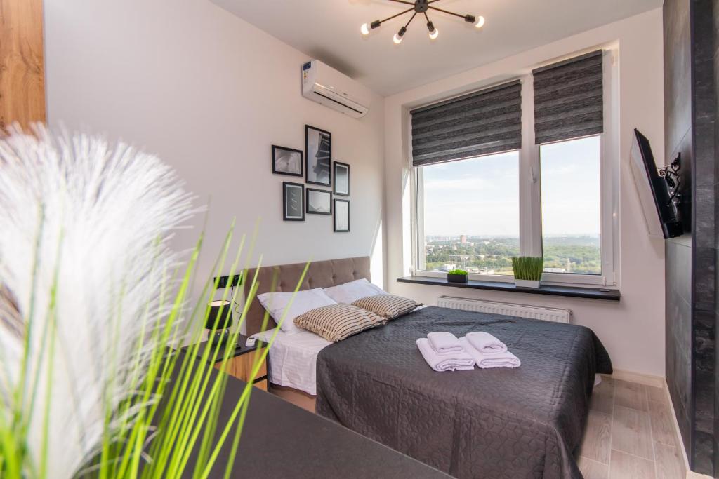 a bedroom with a bed with two towels on it at Апартаменти MYFREEDOM поблизу метро Теремки in Kyiv