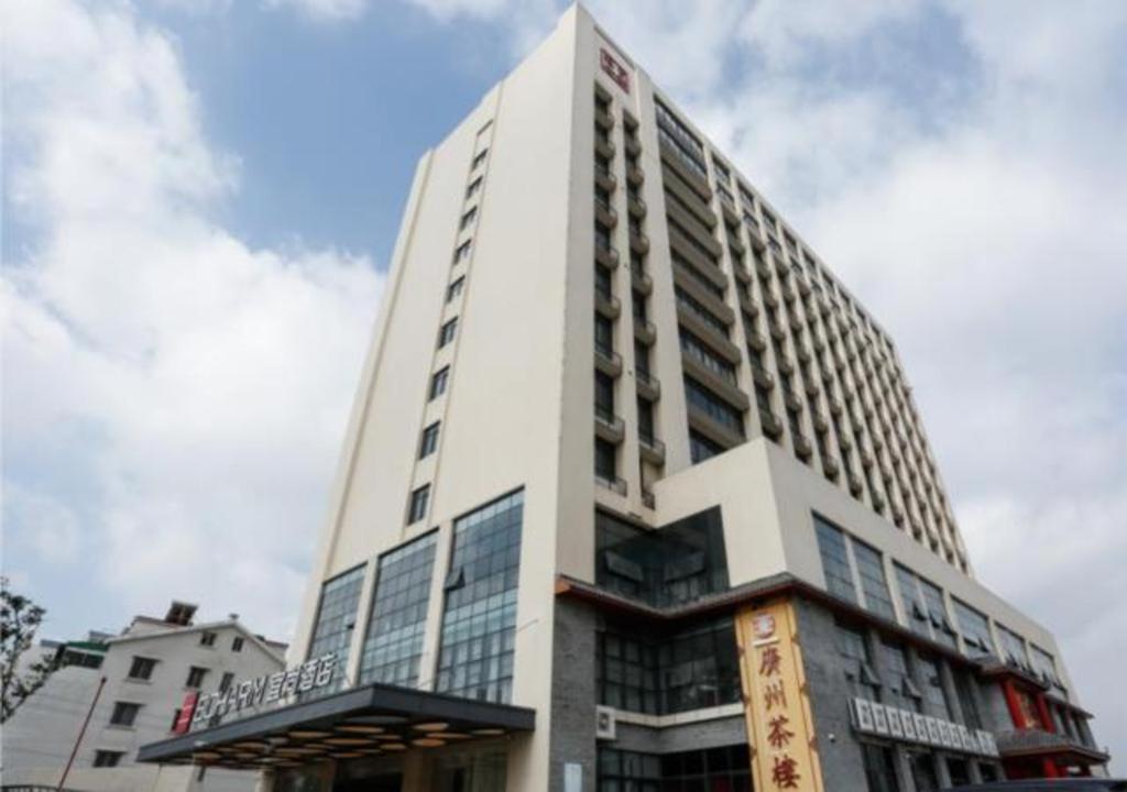 um edifício branco alto com um cartaz em Echarm Hotel Liuzhou Liunan Wanda Plaza em Liuzhou