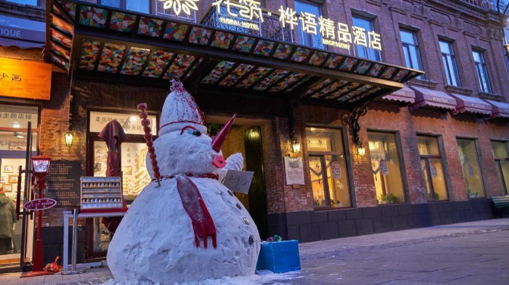 a snowman on a street in front of a building at Floral Hotel Birch's Story Harbin in Harbin