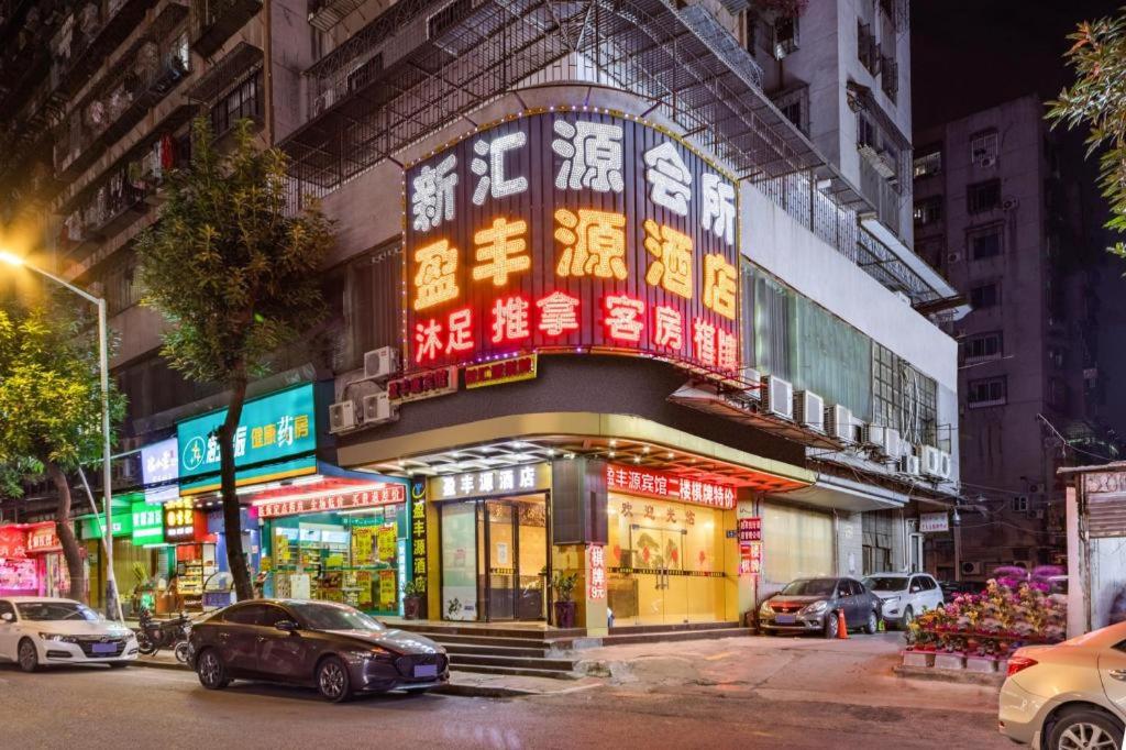 a building with neon signs on the side of it at Ying Feng Yuan Hotel in Guangzhou