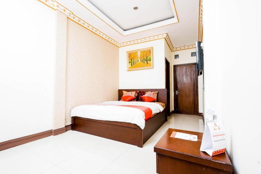 a bedroom with a bed and a desk in a room at OYO 2400 Maleo Exclusive Residence in Bandung