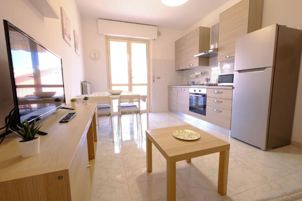 una cucina con un tavolo e un frigorifero bianco di Orchidea Luxury - Pineto Vacanza a Pineto