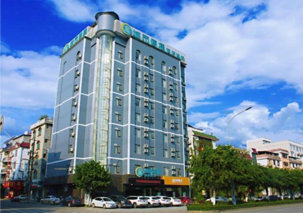 ein hohes Gebäude mit davor geparkt in der Unterkunft City Comfort Inn Baise Tiandong in T'ien-tung