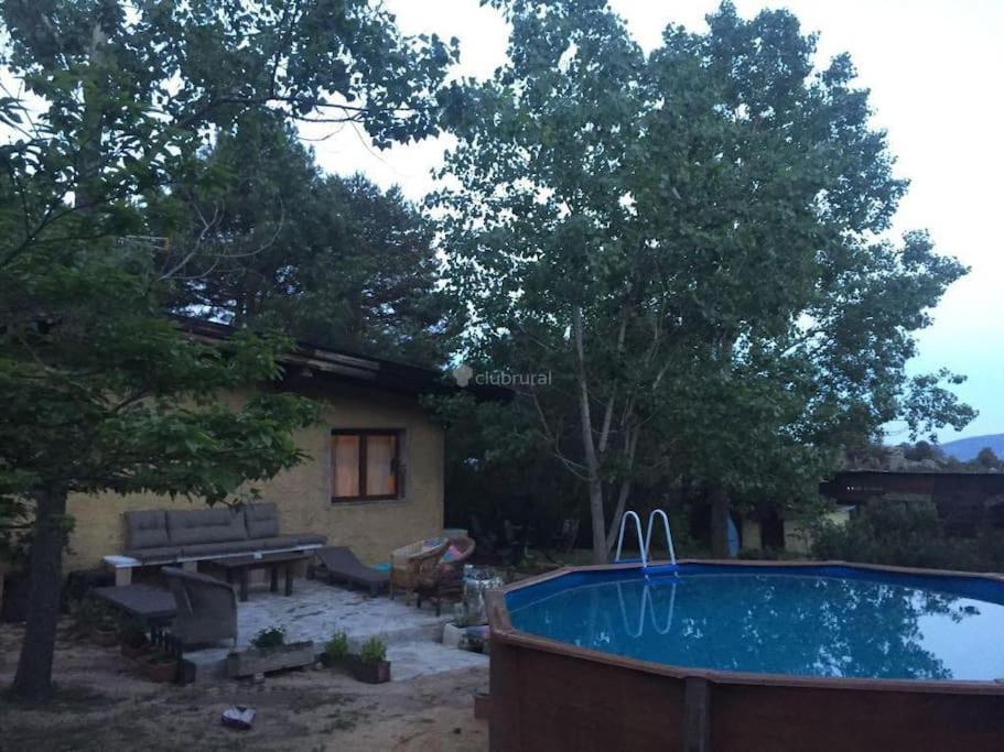 einen Hinterhof mit einem Pool und einem Haus in der Unterkunft villa Pedriza II in Mataelpino