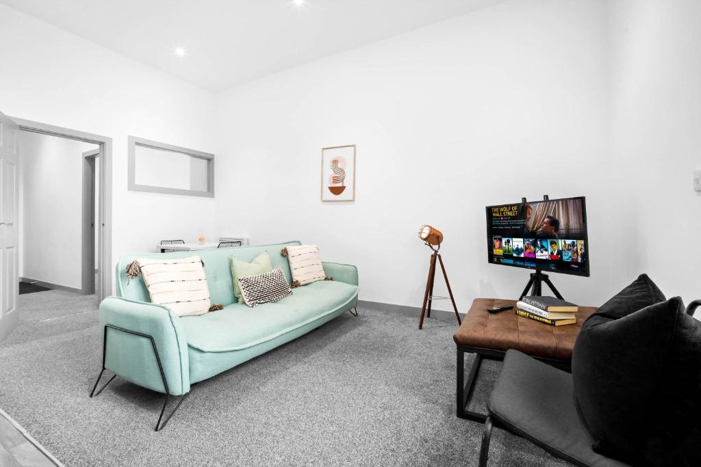 a living room with a blue couch and a table at New Apartment in Brierley Hill - Parking - Wifi - Netflix - Top Rated - 309O in Birmingham