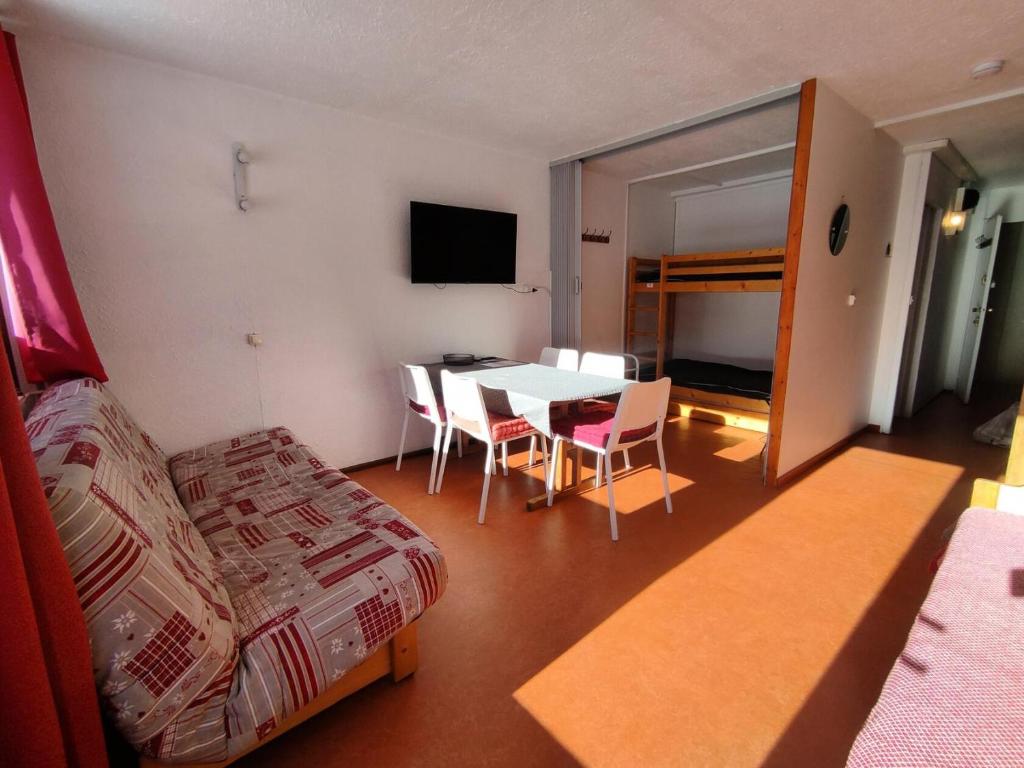 a room with a bed and a table and chairs at Résidence Pelvoux - Studio pour 4 Personnes 844 in Aime-La Plagne