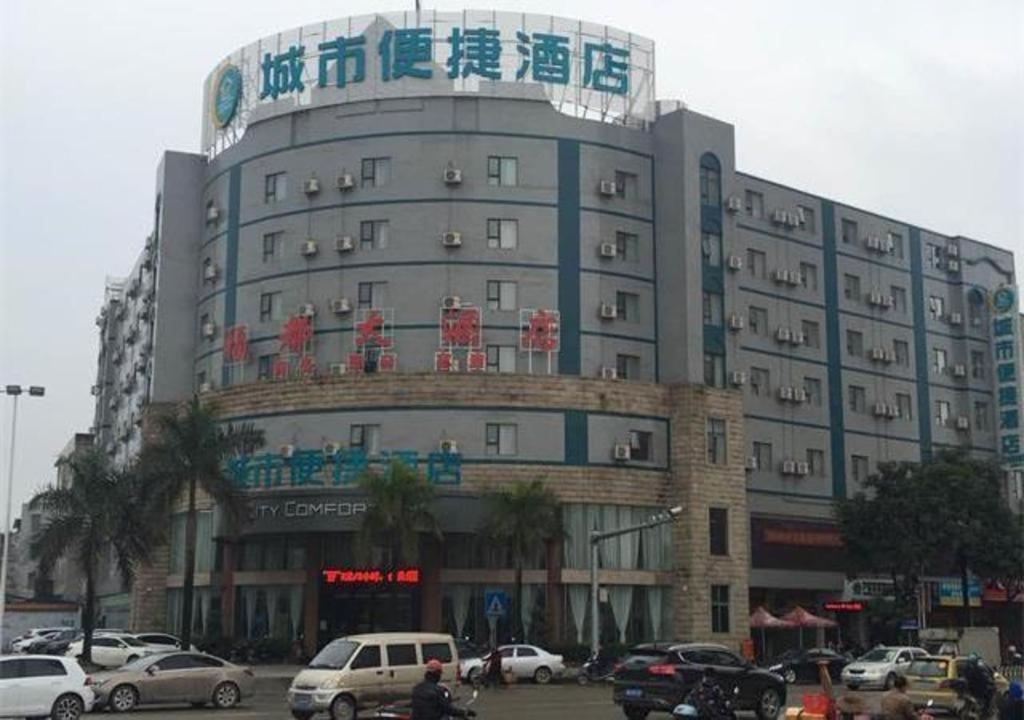 ein großes Gebäude mit Autos auf einem Parkplatz in der Unterkunft City Comfort Inn Yulin Yufu Road Industrial Products Market in Yulin