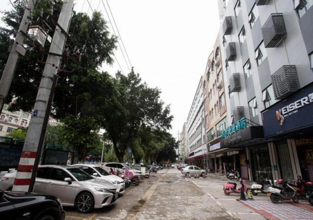 una concurrida calle de la ciudad con coches aparcados en la calle en City Comfort Inn Beiliu Yongfeng Plaza Chengnan Bus Station, en Beiliu