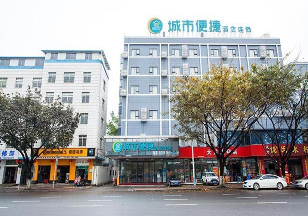 a group of buildings on a city street with cars at City Comfort Inn Liuzhou The Mixc Xijiang Road in Liuzhou