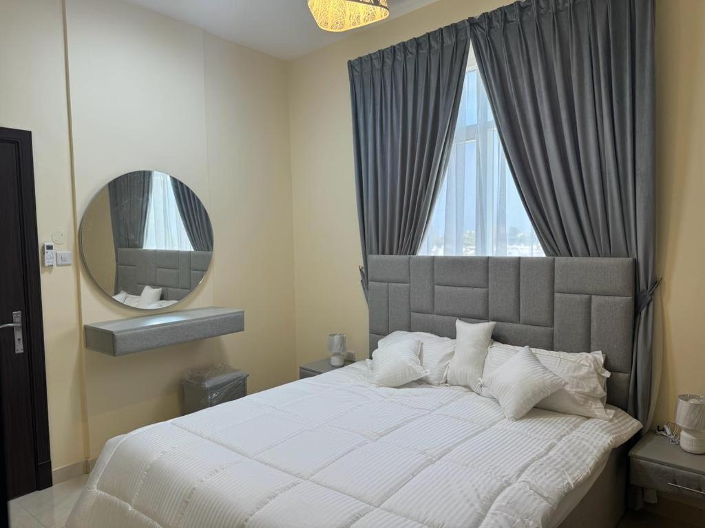 a bedroom with a large bed and a mirror at Star building in Khor Fakkan