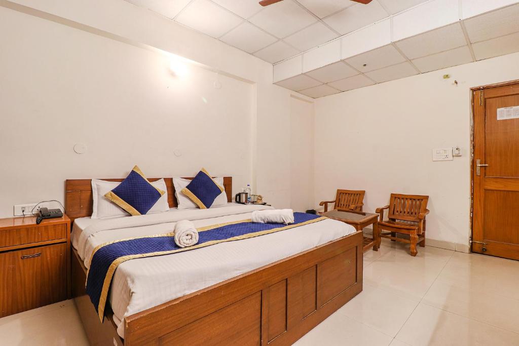 1 dormitorio con 1 cama grande y 2 sillas en Hotel PARAS TOWER en Dehradun