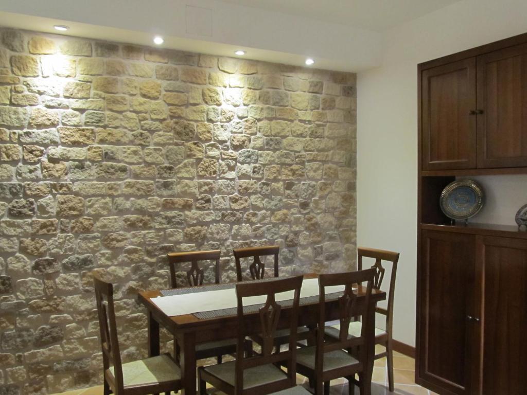 a dining room with a stone wall and a table and chairs at Soggiorno in Relax in Correggioverde