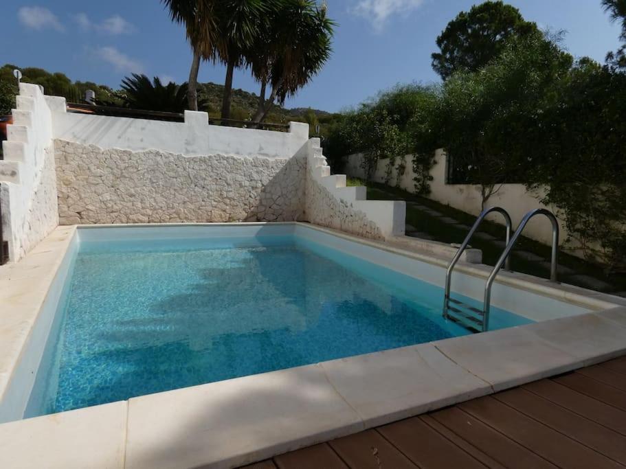 una piscina de agua azul en una casa en Villa Turandot-swimming pool-close to the beach, en Torre delle Stelle