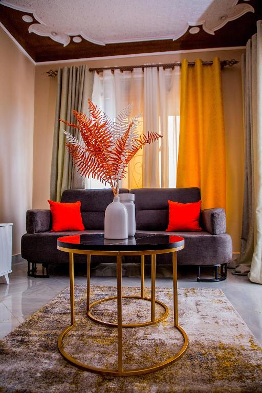 a living room with a table and a couch at The Cozy Haven Kisasi in Kampala