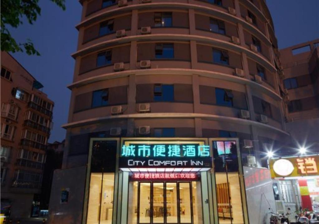 a tall building with a sign in front of it at City Comfort Inn Liuzhou Liunan Wanda RT-Mart in Liuzhou