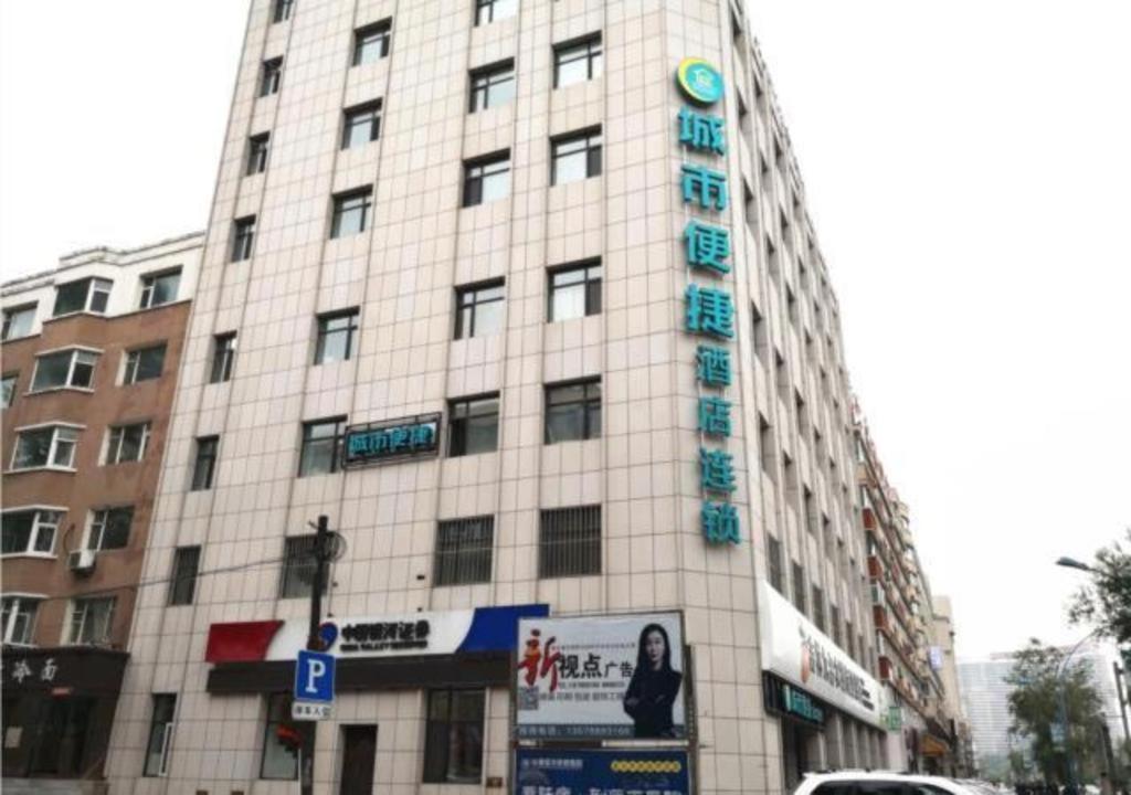 City Comfort Inn Changchun Jida First Hospital Xi Minzhu Street في تشانغتشون: مبنى أبيض طويل عليه علامة