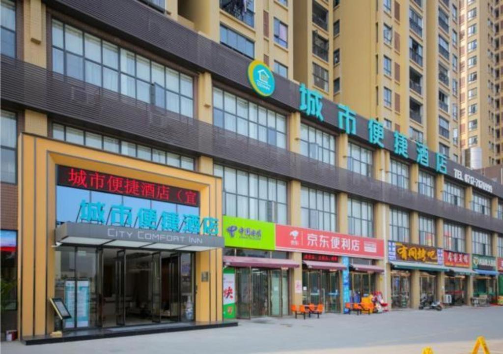 a large building with signs on the side of it at City Comfort Inn Yichang Yiling Bus Station Wanda Plaza in Baiyang