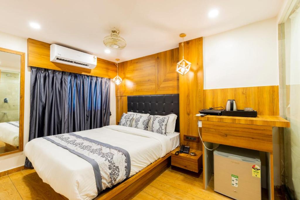 a small bedroom with a bed and a television at Hotel Village Residency in Mumbai