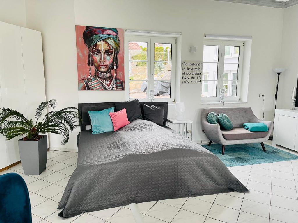 1 dormitorio con 1 cama, 1 silla y 1 pintura en Haus Rehlein, en Pleiskirchen
