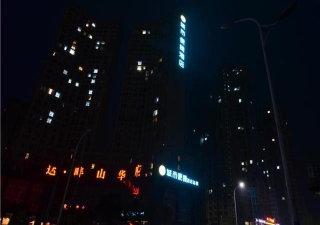 a city skyline at night with tall buildings at City Comfort Inn Huanggang Qichun Exhibition Center in Qichun