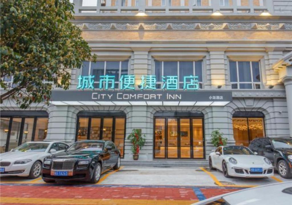 a city corrupt inn with cars parked in front of it at City Comfort Inn Liuzhou Chengzhong Wanda Haiguan in Liuzhou