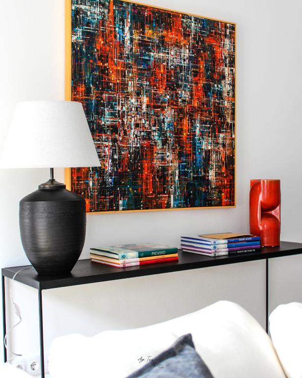 a table with a lamp and a painting on the wall at Nomad Houses - Ap Tereno in Beja