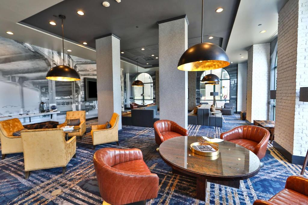a lobby with a table and chairs and a kitchen at Hilton Garden Inn Savannah Historic District in Savannah