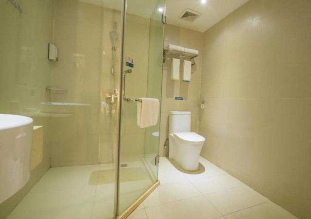 a bathroom with a glass shower and a toilet at City Comfort Inn Yibin Cuipingshan Park in Nanguang