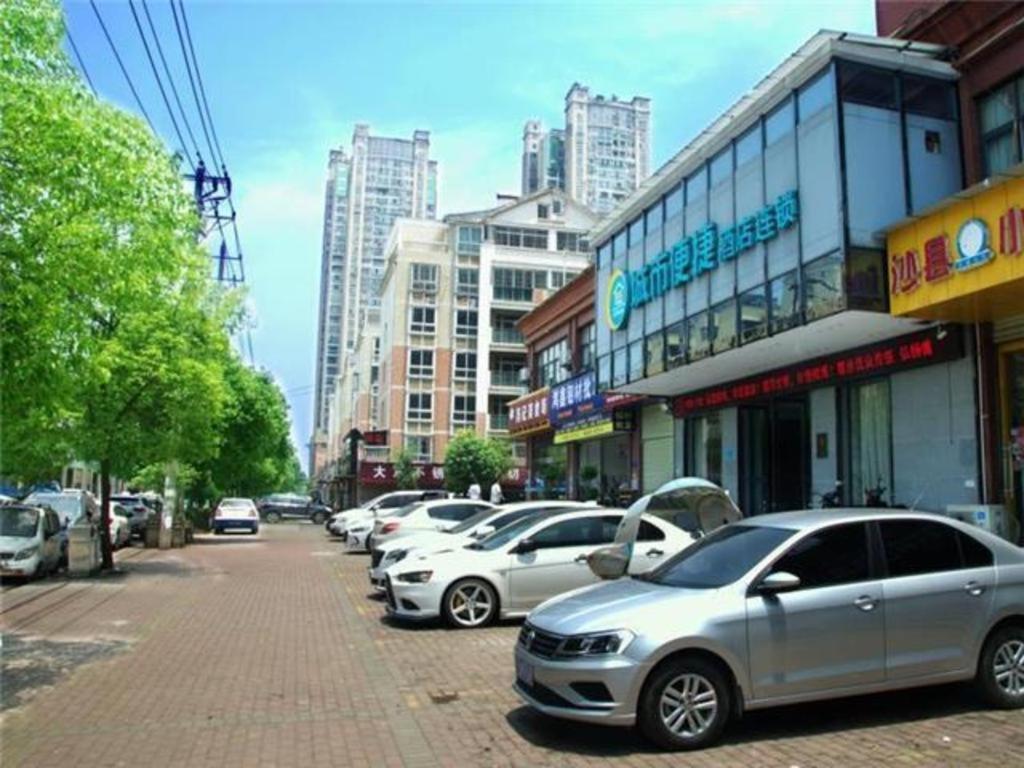eine Reihe parkender Autos auf einer Stadtstraße in der Unterkunft City Comfort Inn Huangshi Wanda Plaza Huashan Road in Huangshi